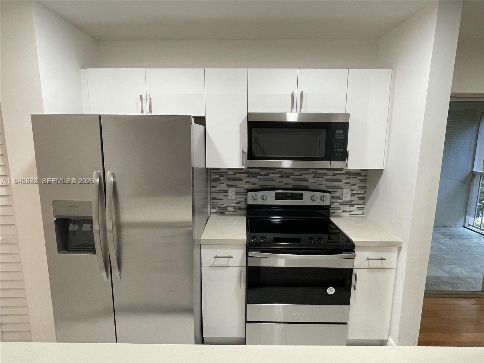 15325 Southwest 106th Terrace, Unit 618 Miami, FL 33196 - Photo 9 of 27 a kitchen with cabinets and stainless steel appliances