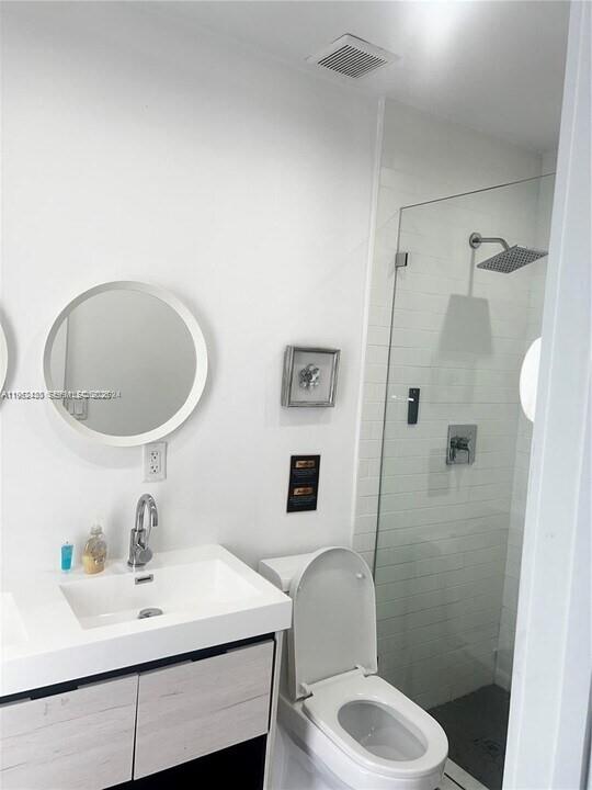15 Northwest 52nd Street Miami, FL 33127 - Photo 18 of 28 a bathroom with a sink toilet a mirror and shower