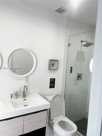 a bathroom with a sink toilet a mirror and shower