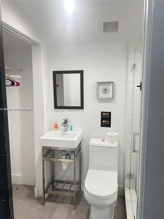 15 Northwest 52nd Street Miami, FL 33127 - Photo 20 of 28 a bathroom with a toilet a sink and mirror