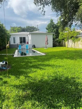 a view of a house with a backyard and a patio