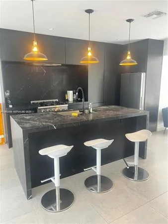 a kitchen with a sink cabinets and chandelier