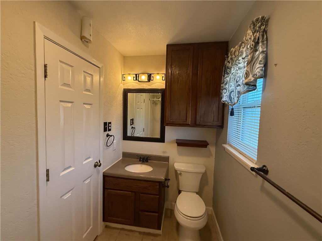 10502 Hemlock Road Corpus Christi, TX 78410 - Photo 14 of 31 a bathroom with a sink a toilet and shower curtain