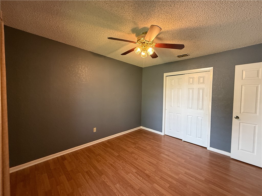 10502 Hemlock Road Corpus Christi, TX 78410 - Photo 16 of 31 an empty room with wooden floor fan and windows