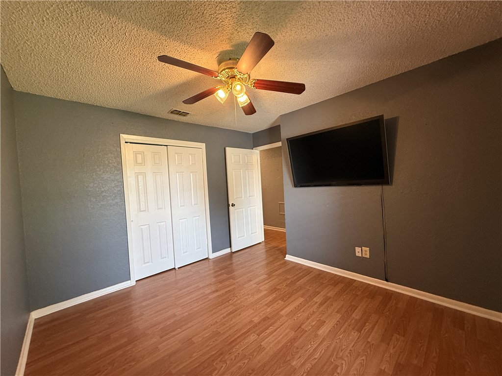 10502 Hemlock Road Corpus Christi, TX 78410 - Photo 17 of 31 a view of an empty room with wooden floor and a ceiling fan