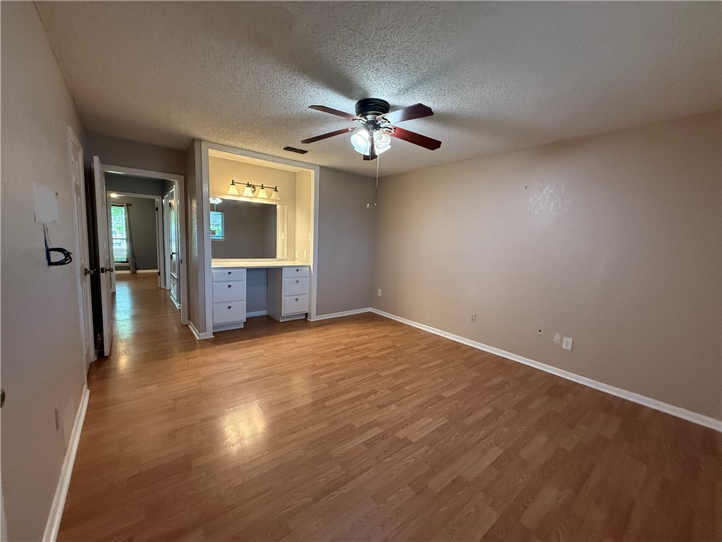 10502 Hemlock Road Corpus Christi, TX 78410 - Photo 24 of 31 an empty room with wooden floor a ceiling fan and closet