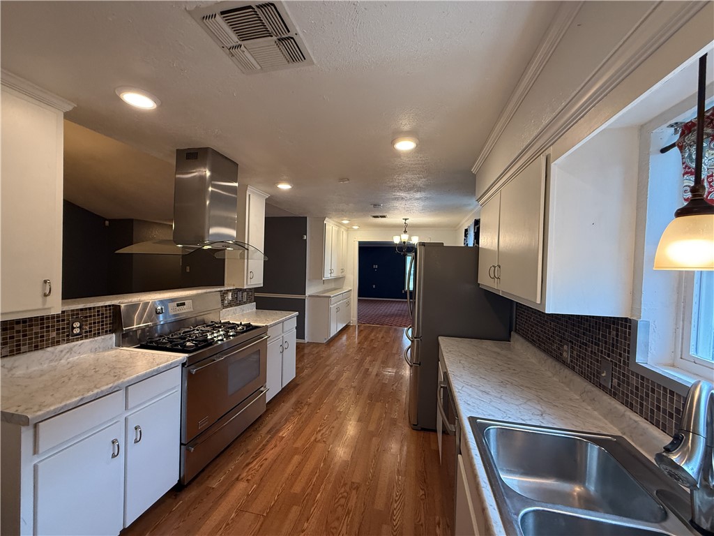 10502 Hemlock Road Corpus Christi, TX 78410 - Photo 3 of 31 a kitchen with stainless steel appliances kitchen island granite countertop a stove a sink and a microwave
