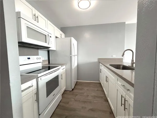 a large kitchen with a refrigerator and a sink