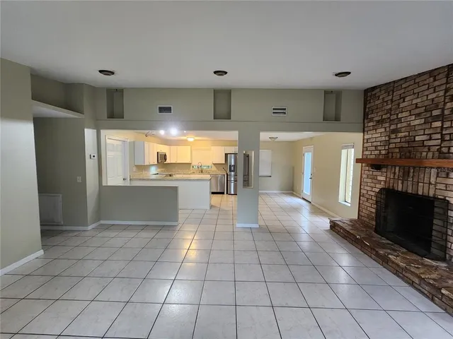 a view of kitchen with granite countertop cabinets and refrigerator