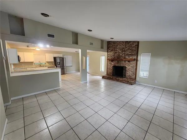 a living room with a fireplace furniture and a kitchen view