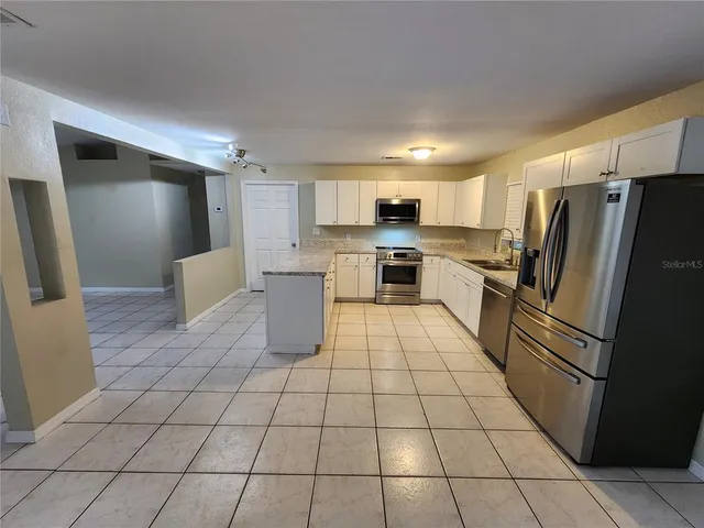a kitchen with stainless steel appliances a refrigerator sink and cabinets