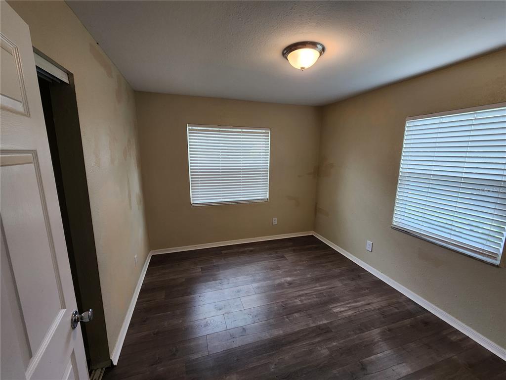 249 Flamingo Road Oak Hill, FL 32759 - Photo 8 of 11 an empty room with wooden floor and windows
