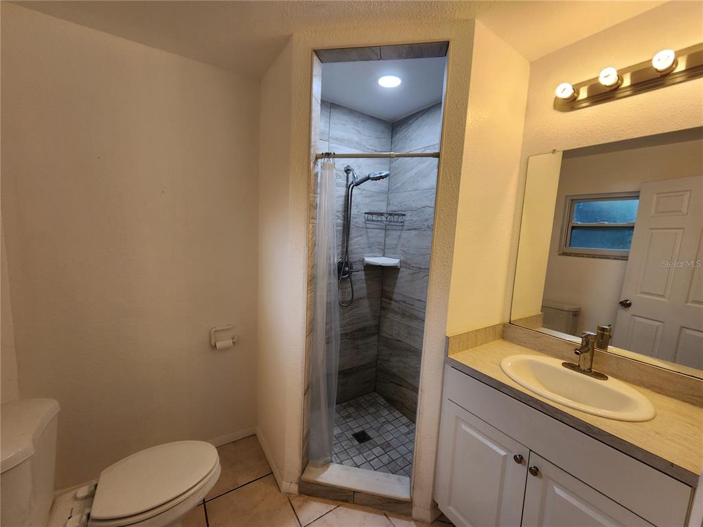 249 Flamingo Road Oak Hill, FL 32759 - Photo 10 of 11 a bathroom with a sink a toilet and shower