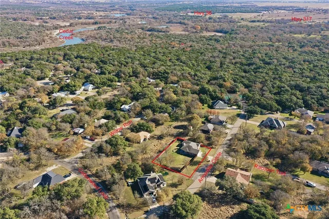 a view of a house with a big yard and large trees