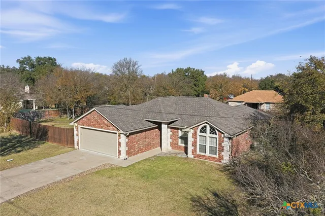 a front view of a house with a yard and trees