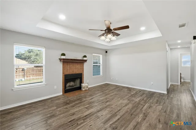 a view of an empty room with a window and fireplace