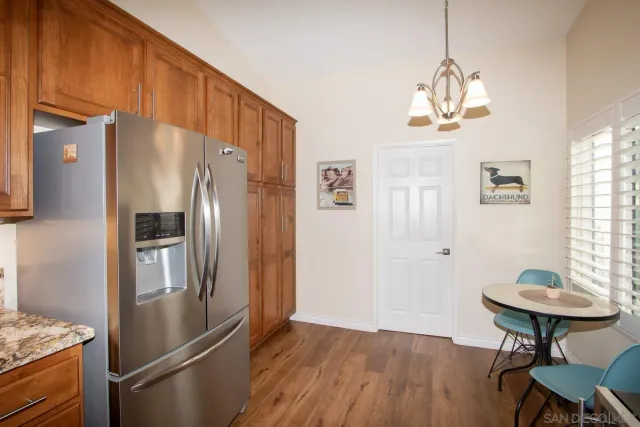 a kitchen with stainless steel appliances a refrigerator a sink a stove a dining table and chairs