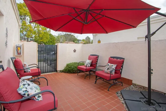 a view of a patio with a table and chairs under an umbrella