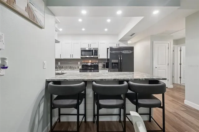 a kitchen with stainless steel appliances granite countertop a stove and a refrigerator