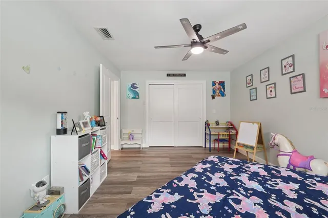 a bedroom with a bed a dresser and a flat screen tv