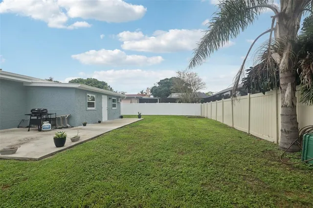 an aerial view of residential houses with outdoor space and trees