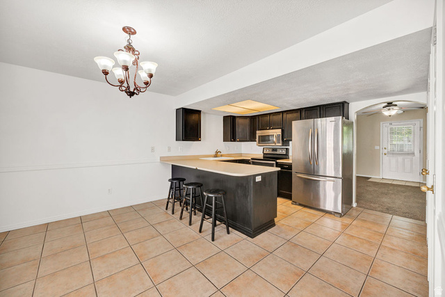 2 West 1780 North Logan, UT 84341 - Photo 6 of 24 Kitchen with stainless steel appliances, light countertops, a breakfast bar area, arched walkways, and a peninsula