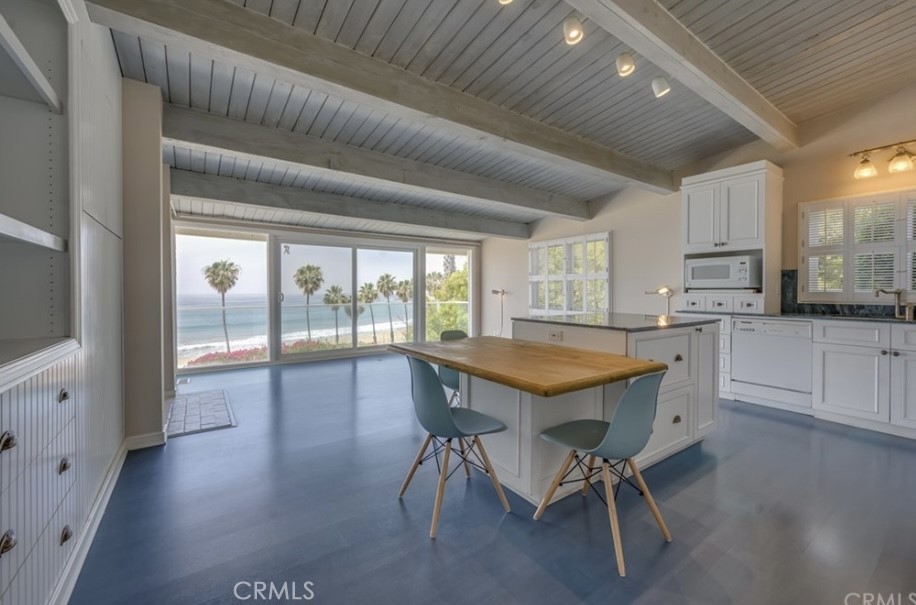 a kitchen with stainless steel appliances granite countertop table chairs sink and cabinets