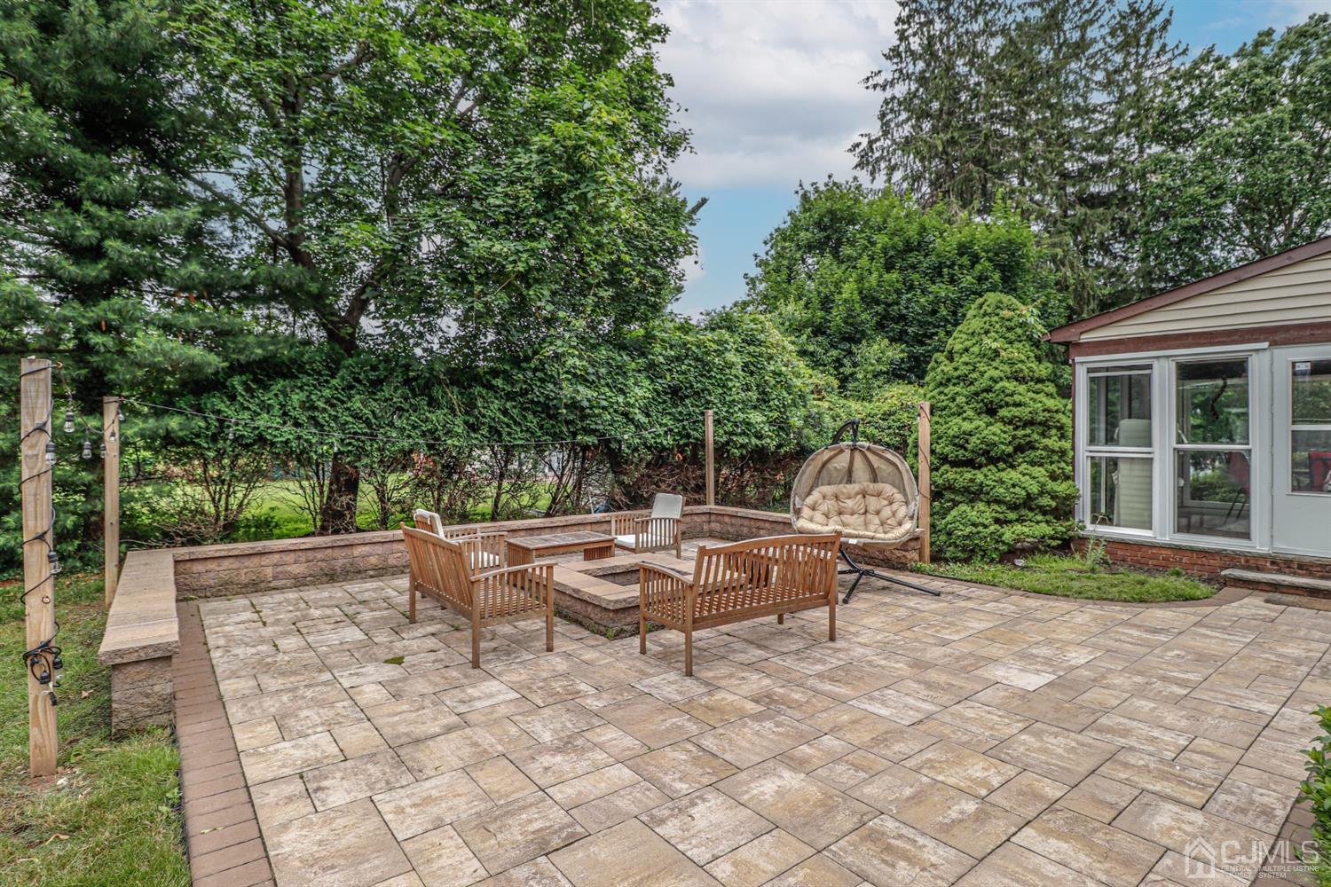 15 Skytop Road Edison, NJ 08820 - Photo 22 of 29 a view of a backyard with table and chairs potted plants and large tree