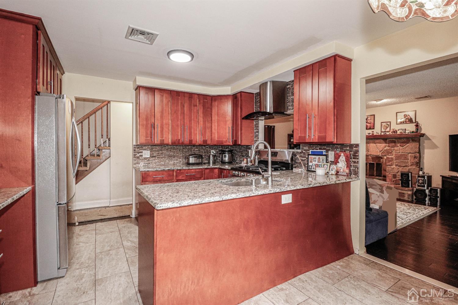 15 Skytop Road Edison, NJ 08820 - Photo 7 of 29 a kitchen with stainless steel appliances granite countertop a refrigerator a stove and a sink with wooden floor