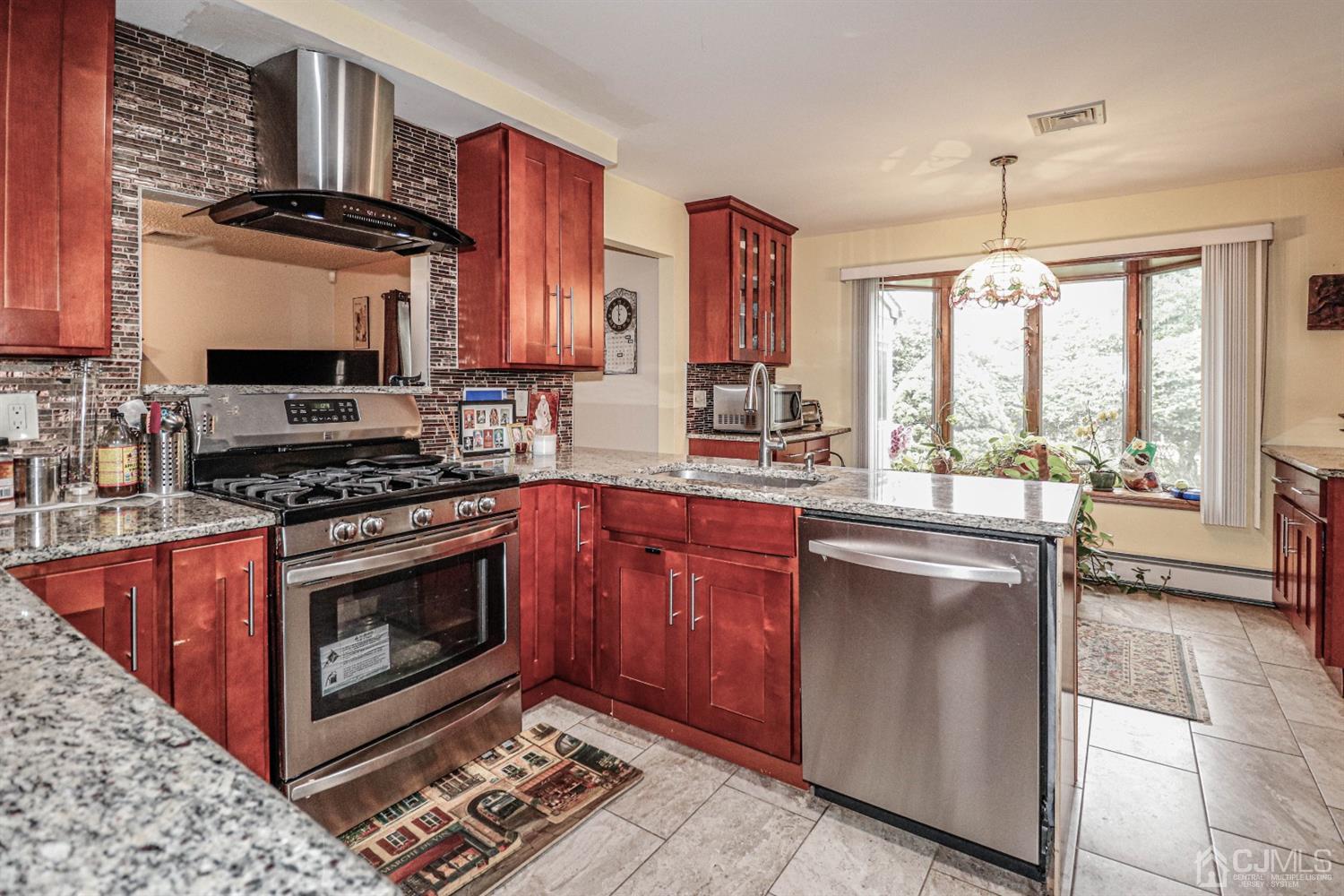 15 Skytop Road Edison, NJ 08820 - Photo 8 of 29 a kitchen with stainless steel appliances granite countertop a stove a sink and a microwave