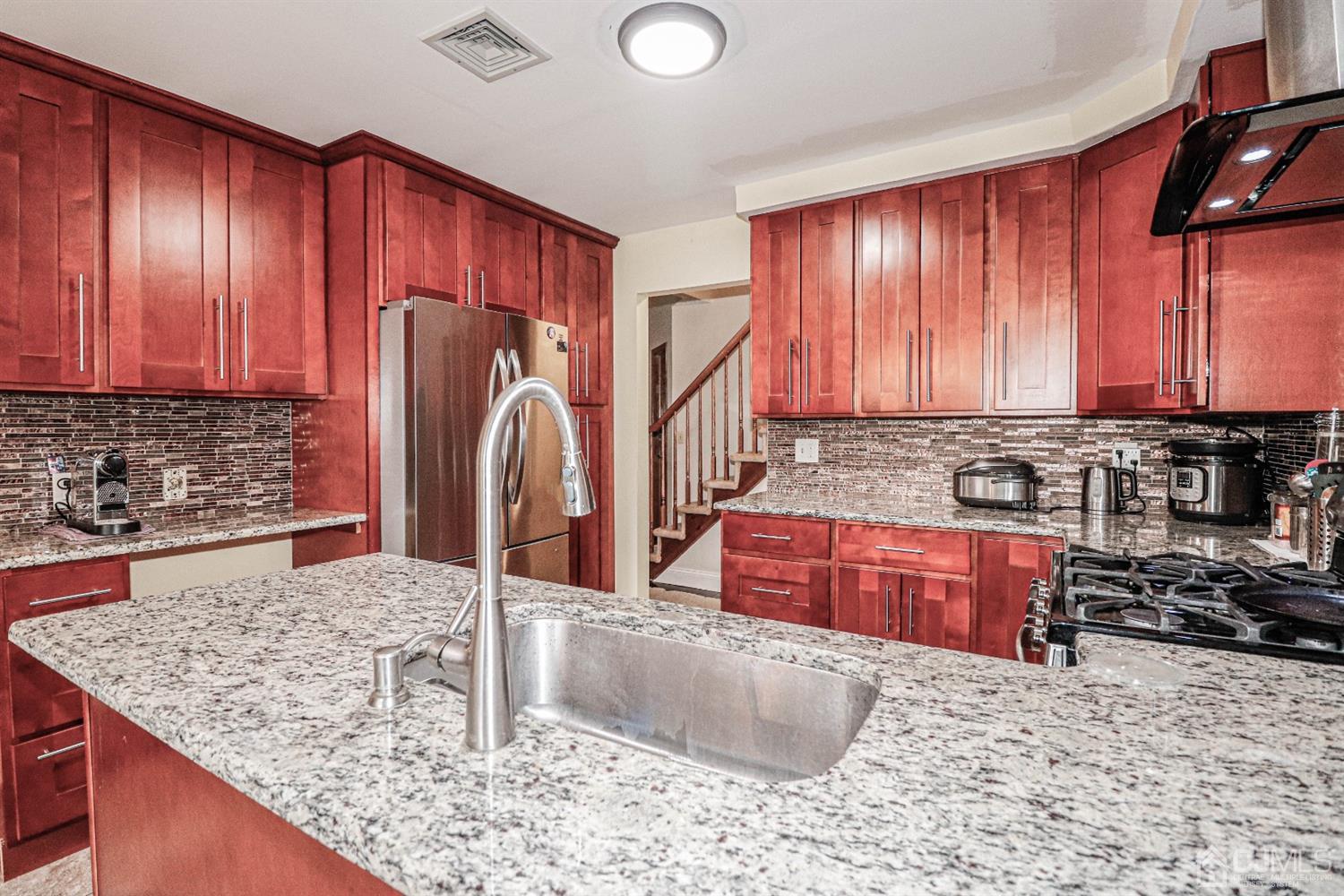 15 Skytop Road Edison, NJ 08820 - Photo 10 of 29 a kitchen with stainless steel appliances granite countertop a stove a sink and a microwave