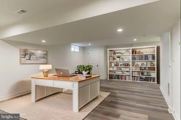 a work room with wooden floor and furniture