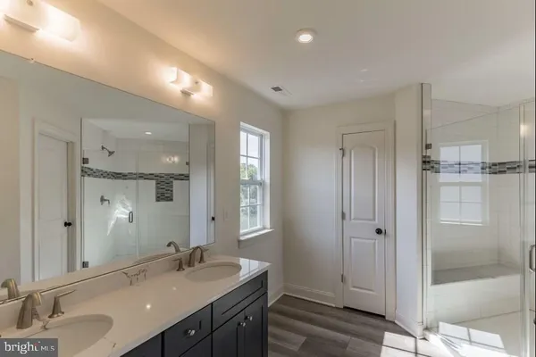 a bathroom with a granite countertop sink mirror and shower