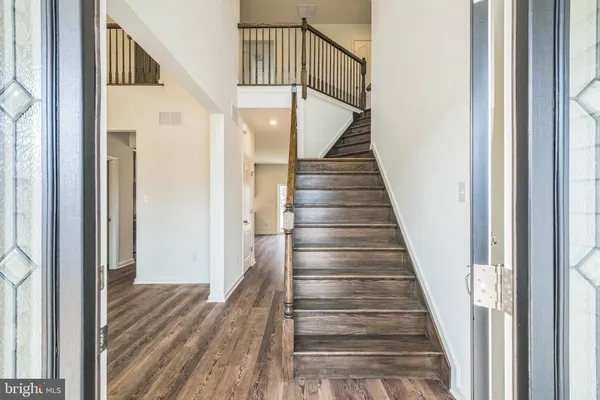 a view of staircase with wooden floor and white walls