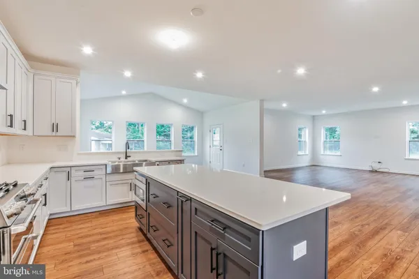a kitchen with granite countertop a sink and stove top oven