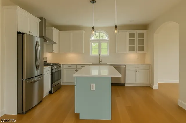 a kitchen with kitchen island a counter top space a refrigerator a sink a stove and a window