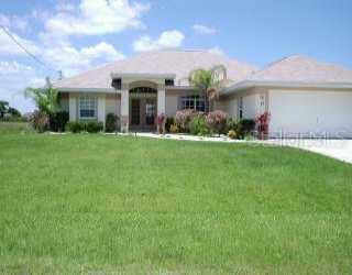 77 Tournament Road Rotonda West, FL 33947 - Photo 1 of 1 a front view of a house with a yard and garage