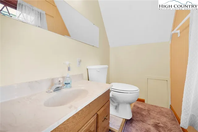 a view of a hallway and a livingroom with furniture