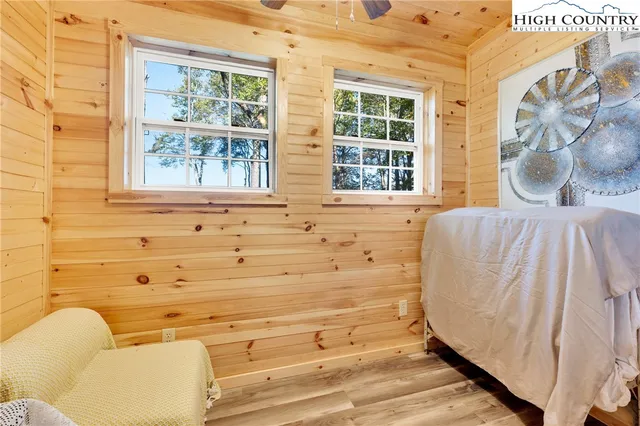 a bedroom with a bed and a dresser with wooden floor