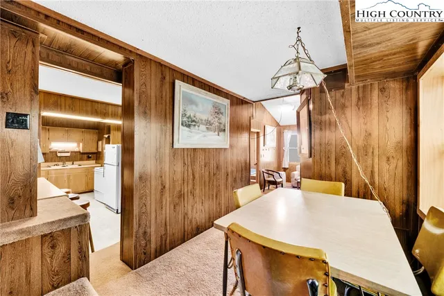 a bedroom with a bed and dresser with wooden floor