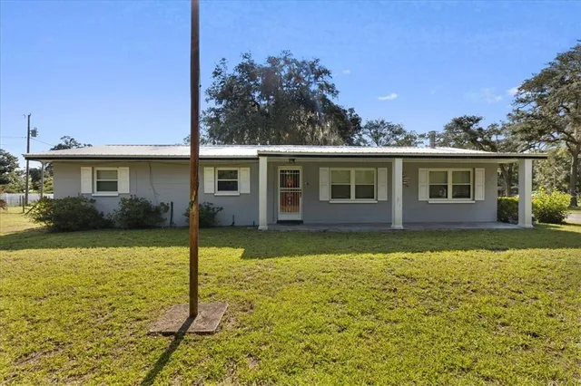 a view of a house with yard and tree s