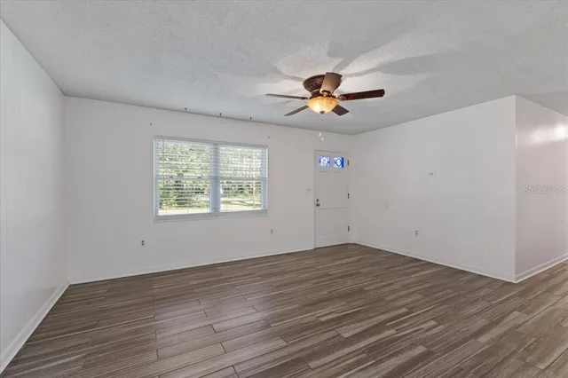 wooden floor in an empty room with a window
