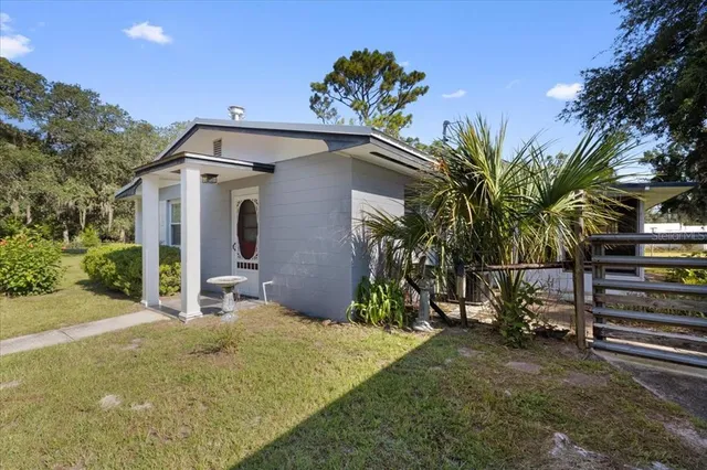a view of a house with a yard balcony and tree