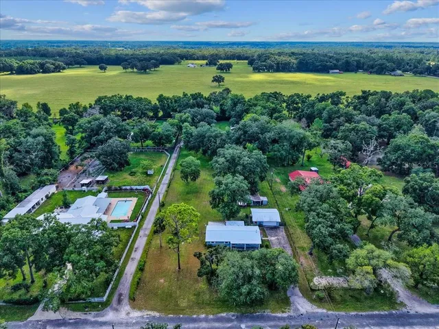 an aerial view of a house with a garden and lake view