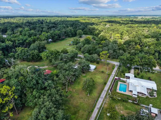 a view of a dining room with floor to ceiling window and potted plants