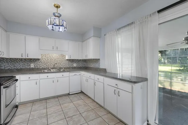 a kitchen with granite countertop white cabinets and white appliances