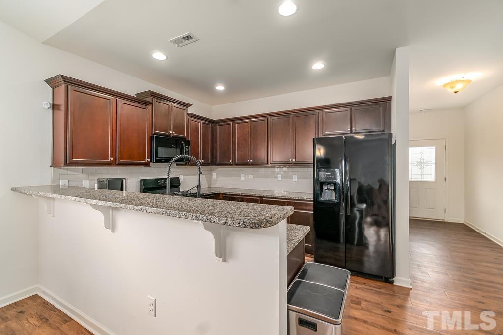 1505 Stark Spring Street Raleigh, NC 27610 - Photo 12 of 22 a kitchen with stainless steel appliances granite countertop a refrigerator and a stove top oven