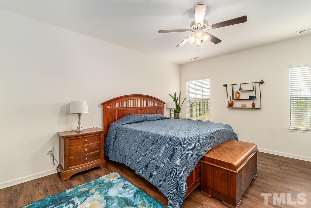 1505 Stark Spring Street Raleigh, NC 27610 - Photo 17 of 22 a bedroom with a bed and a chandelier