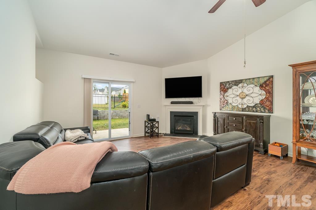 1505 Stark Spring Street Raleigh, NC 27610 - Photo 7 of 22 a living room with furniture a fireplace and a flat screen tv