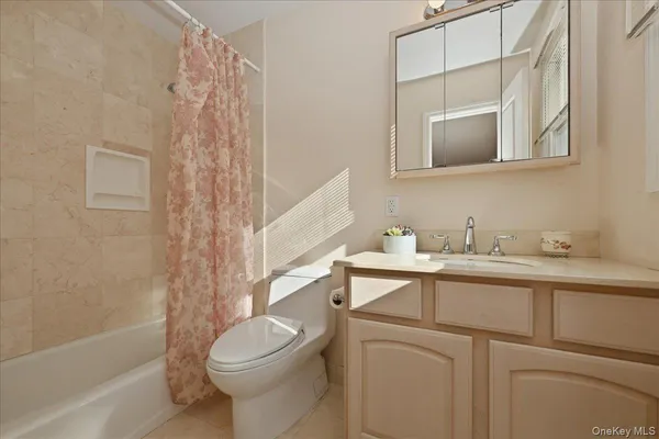 a bathroom with a granite countertop sink mirror vanity and toilet